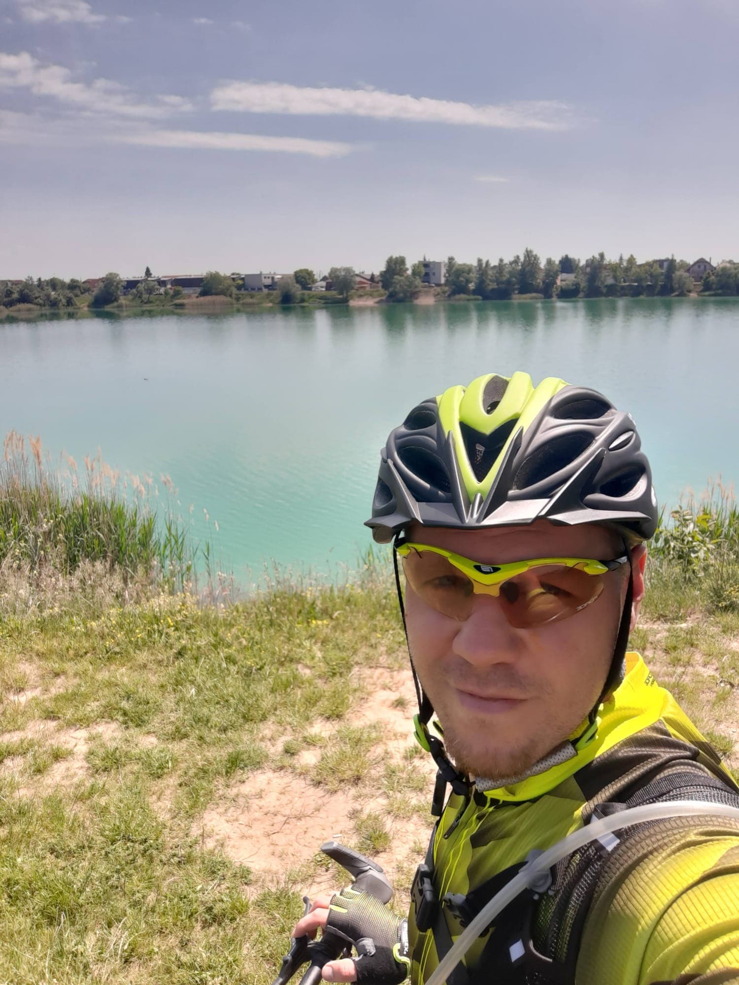 Ivan v cyklistickej prilbe a okuliaroch pri tyrkysovom jazere