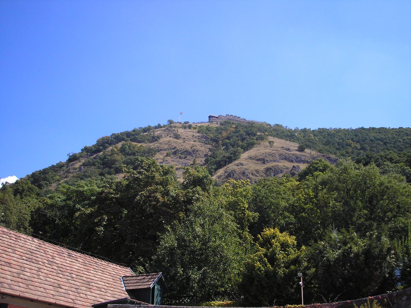 Zalesnený kopec nad Dunajom pod modrou oblohou