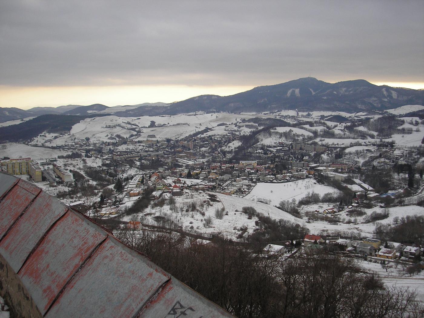 Zasnežené údolie a hory pod oblačnou oblohou